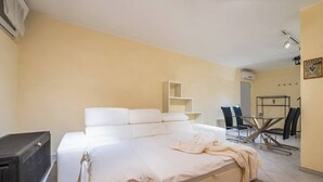 Un dormitorio con una cama grande, una mesita y una silla.