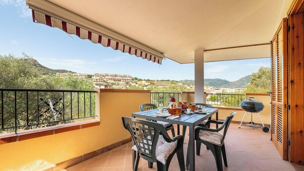 A balcony with a table, chairs, and a grill. - Relax Sea Home by Propertize - Villasimius (Villasimius)