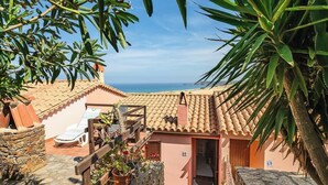 Una villa con techo de tejas, una escalera de piedra y vistas al mar.