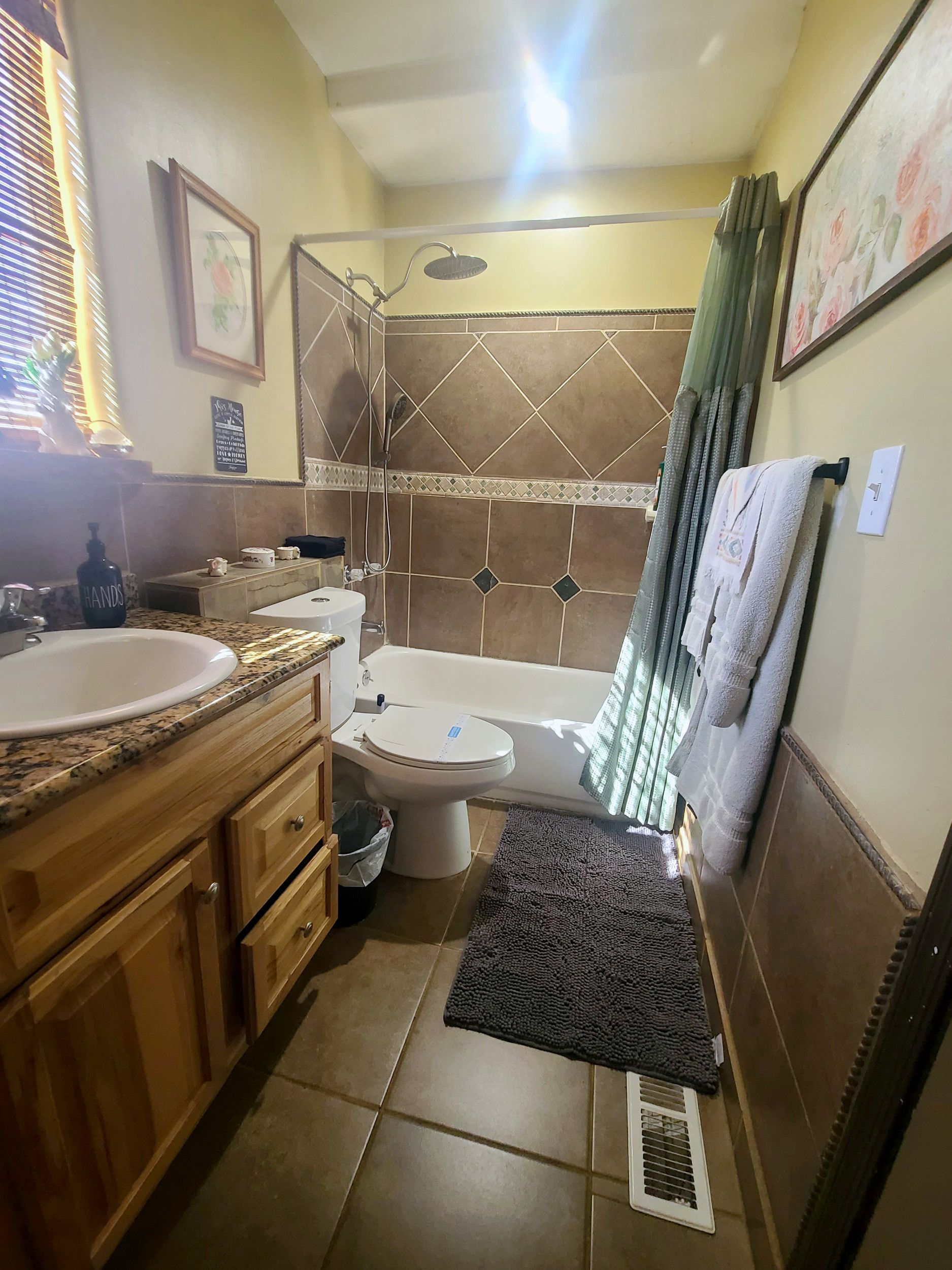 A bathroom with a sink, toilet, shower, and a towel rack.