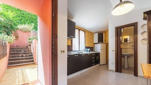 A modern kitchen with dark cabinets, a gas stove, and a white refrigerator.