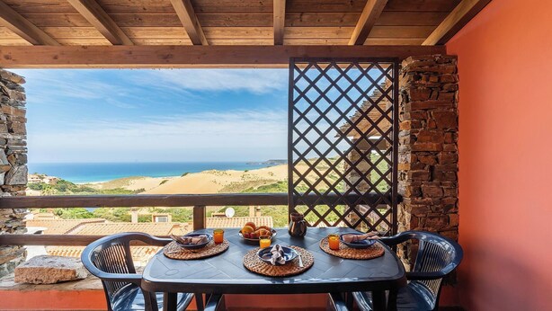 Ein Frühstückstisch mit Blick auf Meer und Hügel.