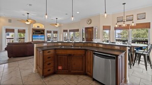 A spacious kitchen with a large island, wooden cabinets, and modern appliances.