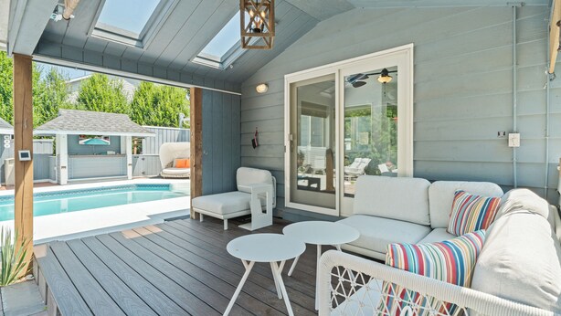 A covered outdoor area with a pool, seating, and a sliding glass door leading to a patio. - Saltwater Pool |Outdoor Kitchen, Bar & TV |Poolside Seating |Gas Fireplace |Near Downtown (Lake Geneva)
