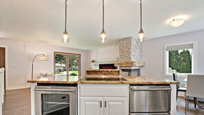 A modern kitchen with granite countertops, stainless steel appliances, and pendant lighting. - Saltwater Pool |Outdoor Kitchen, Bar & TV |Poolside Seating |Gas Fireplace |Near Downtown (Lake Geneva)