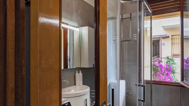 Une salle de bain moderne avec une douche à parois de verre, des toilettes et un lavabo avec un miroir au-dessus.