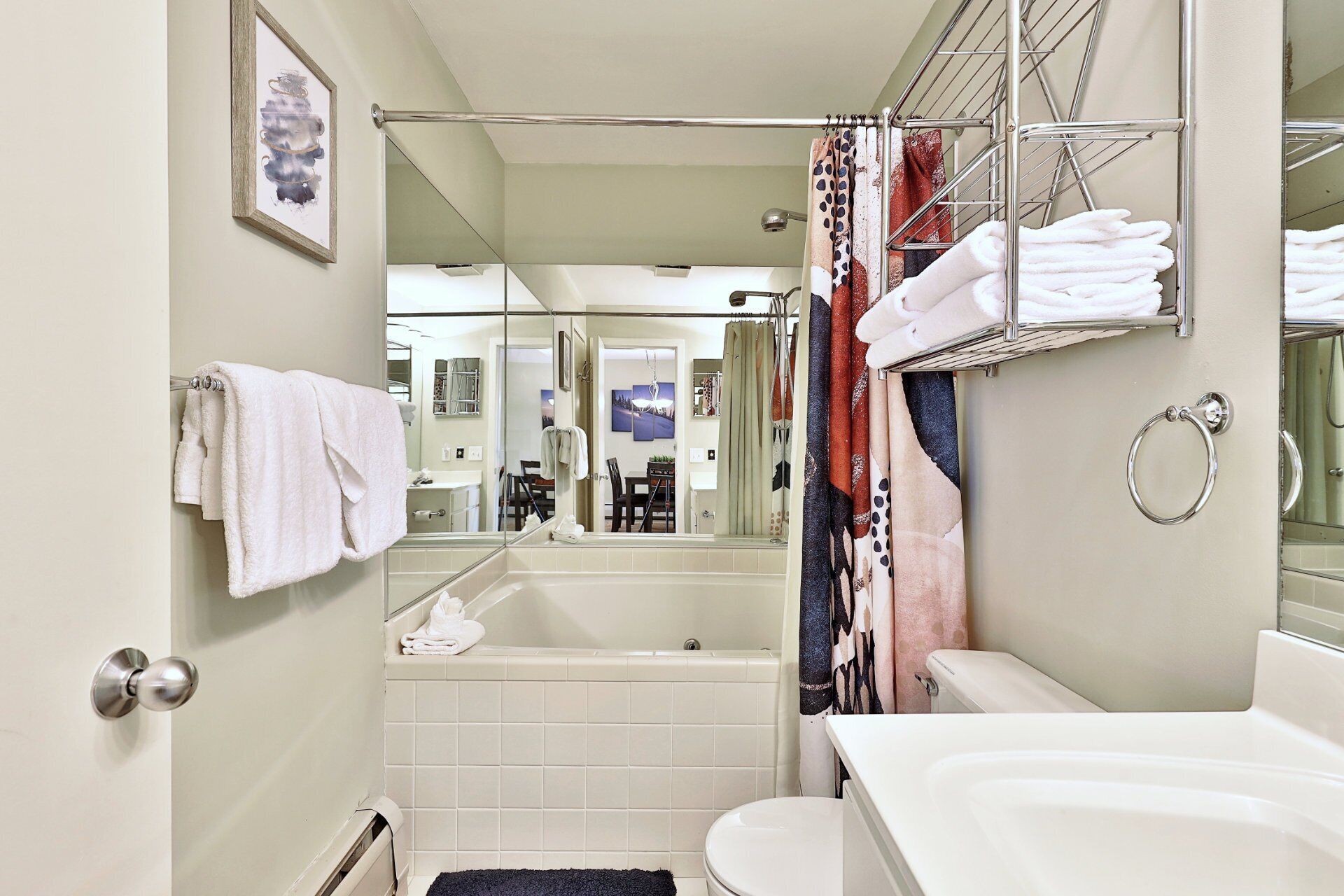 A bathroom with a bathtub, toilet, and a shower curtain.