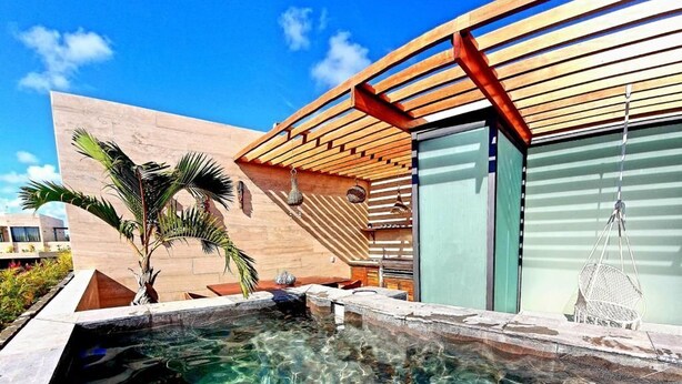A modern outdoor swimming pool with clear water, wooden pergola, and palm trees. - Penthouse de Lujo con 3 Recamaras, Baños, Sala Comedor, Cocina, Jacuzzi Privado (Tulum)