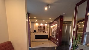 A hotel lobby with a reception desk, a seating area, and a refrigerator. - Hotel TerraMistica Monasterio  (Arequipa)