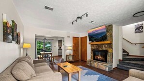 A living room with a fireplace, a sofa, a coffee table, and a staircase. - Sleeps 6 Indoor Pool 10 Mins to Dollywood (Pigeon Forge)