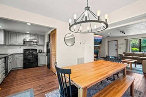 Enjoy meals around the central dining table, surrounded by comfortable chairs and a stylish chandelier.