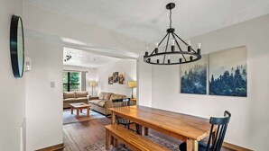 A dining area with a wooden table, benches, and black chairs. There is a chandelier above the table. - Sleeps 6 Indoor Pool 10 Mins to Dollywood (Pigeon Forge)