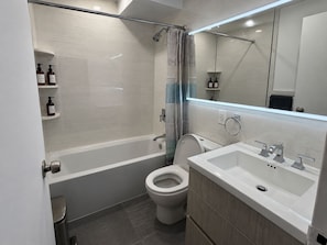 Un baño moderno con bañera, inodoro y lavamanos.