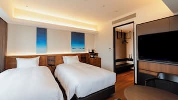 A modern hotel room with two beds, a flat-screen TV, a wooden desk, and a large mirror.