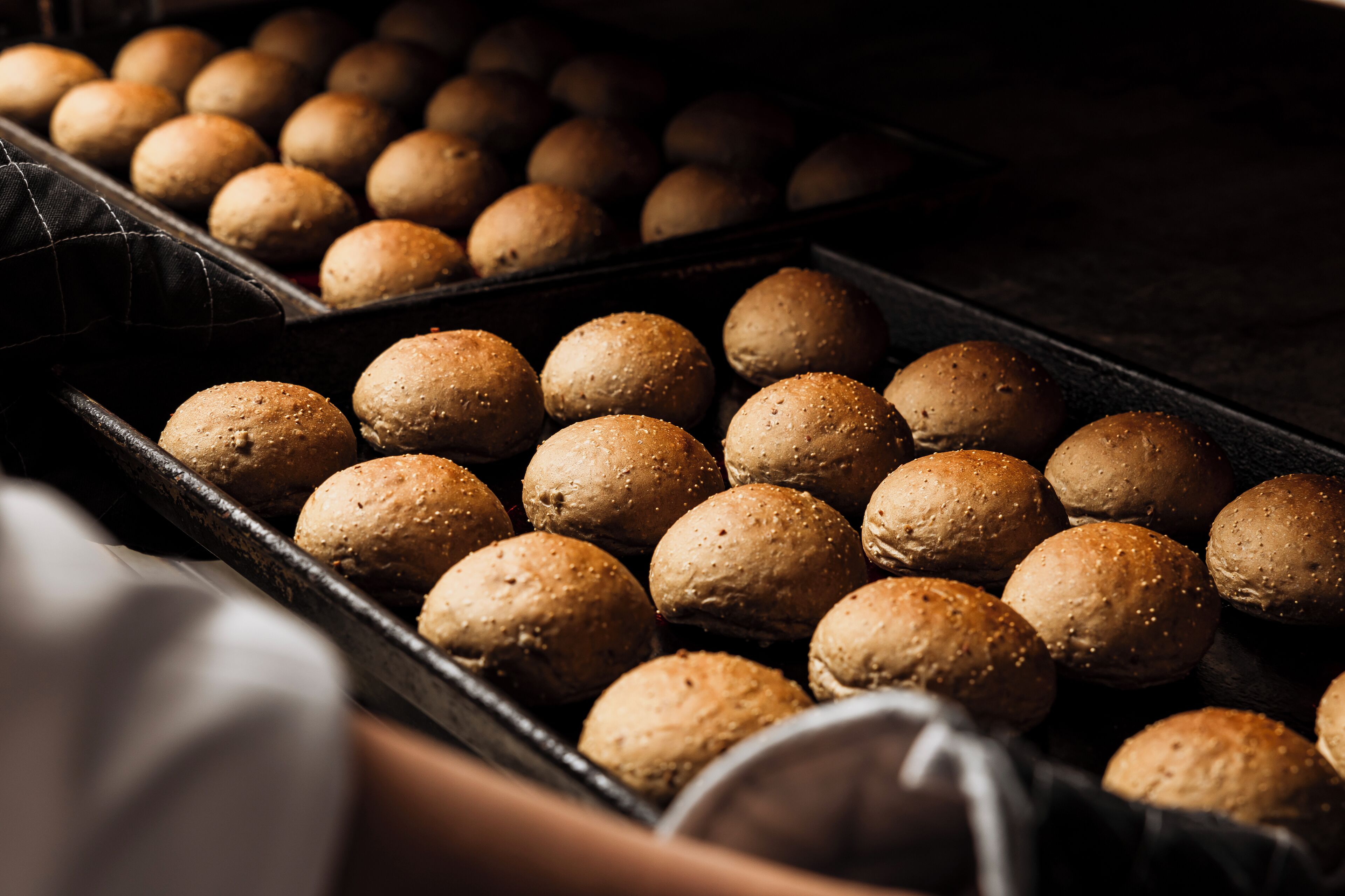A tray of round, textured bread rolls.