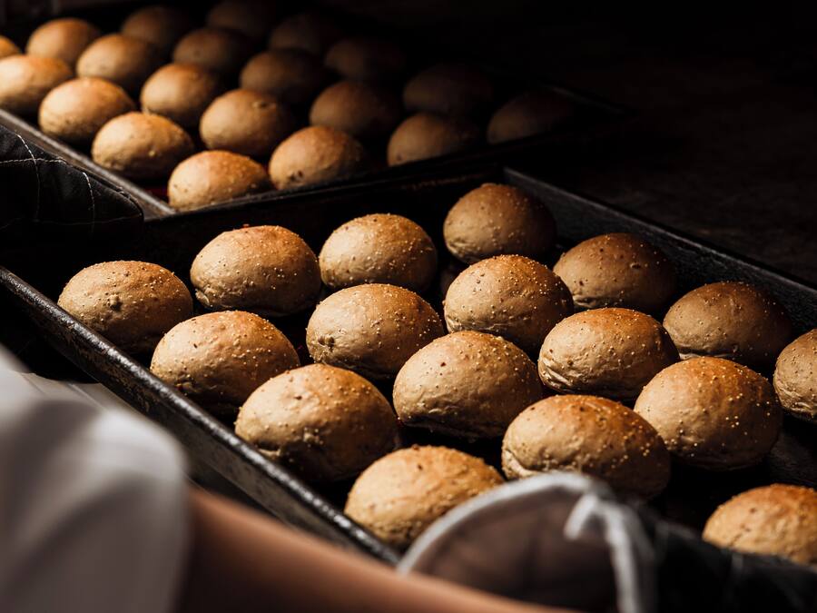 A tray of round, textured bread rolls.