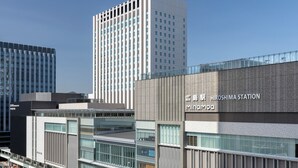 Un edificio moderno con señalización para la estación de Hiroshima y Minamoiq.