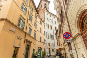 A narrow street with buildings on either side, a no parking sign, and a green door. - 2 BDR Navona Quintessential Charm (Roma)