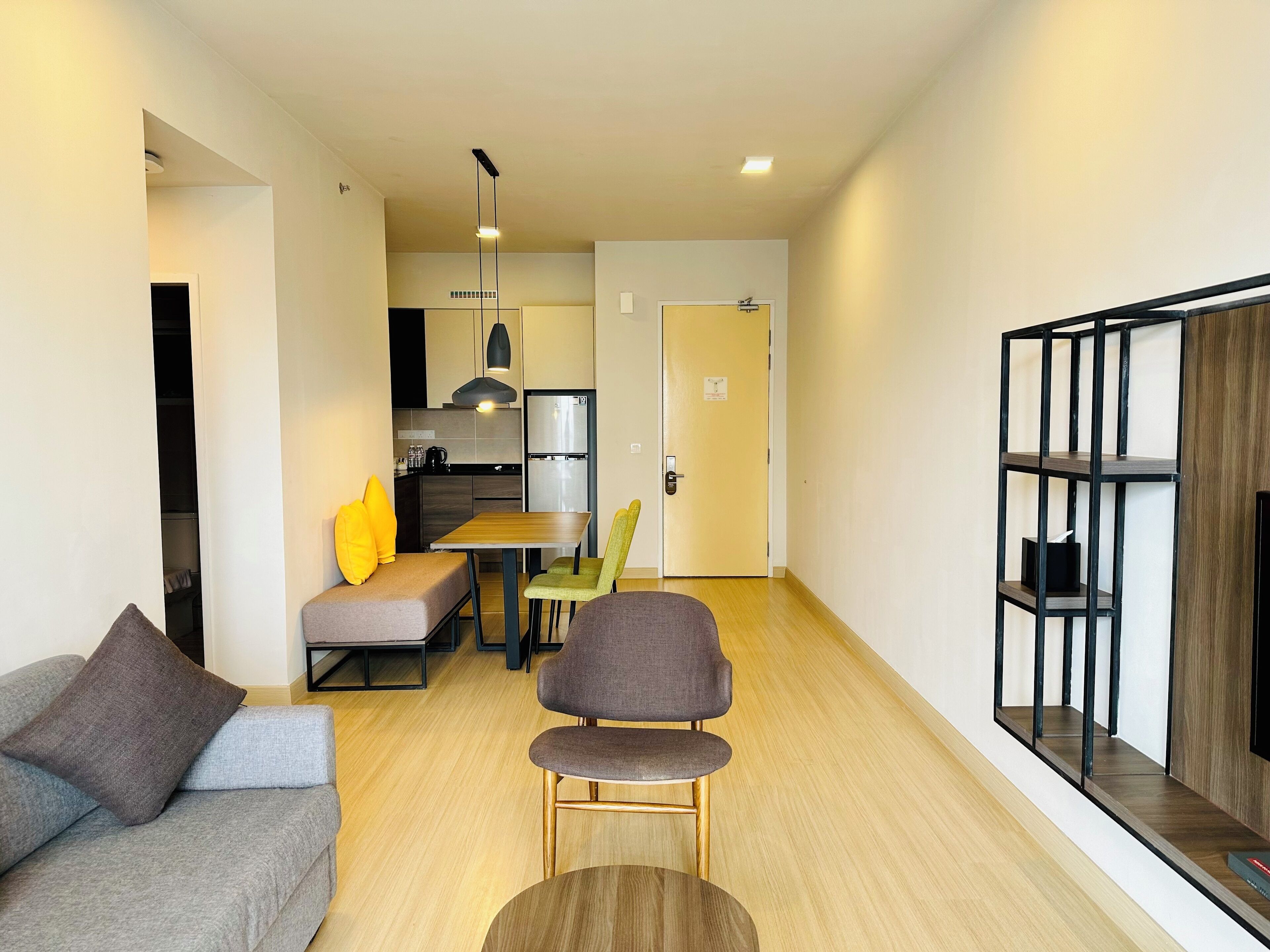 A modern living room with a sofa, two armchairs, a wooden coffee table, and a dining area with a table and chairs.