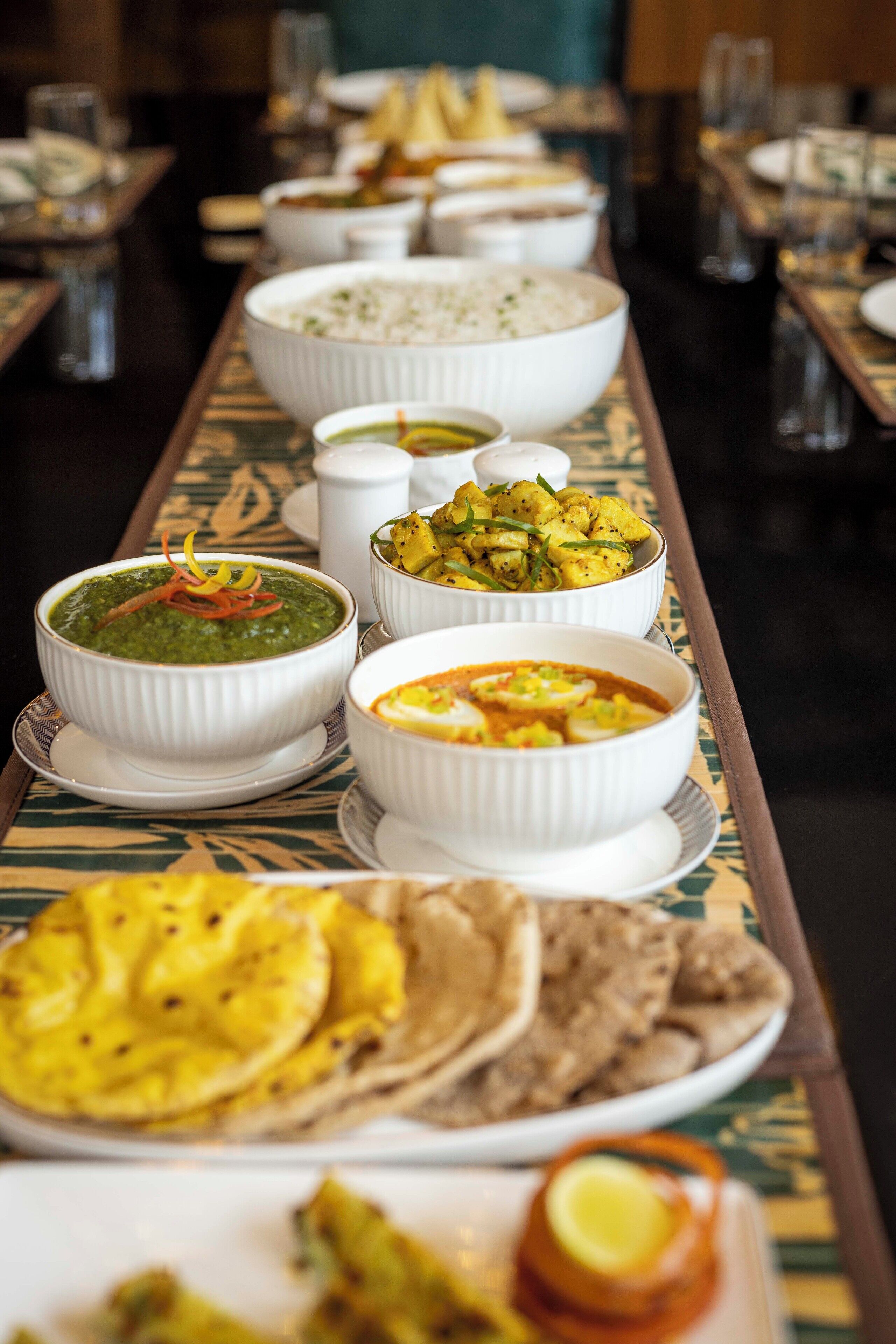 A dining table with various dishes, including bowls of soup and plates of food.