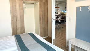A bedroom with a bed, a wardrobe, a desk, and a chair. - Haus Wernerwald - Haus Wernerwald Fewo 6 - Traumhafte Strandnahe Ferienwohnung mit Meerblick (Cuxhaven)