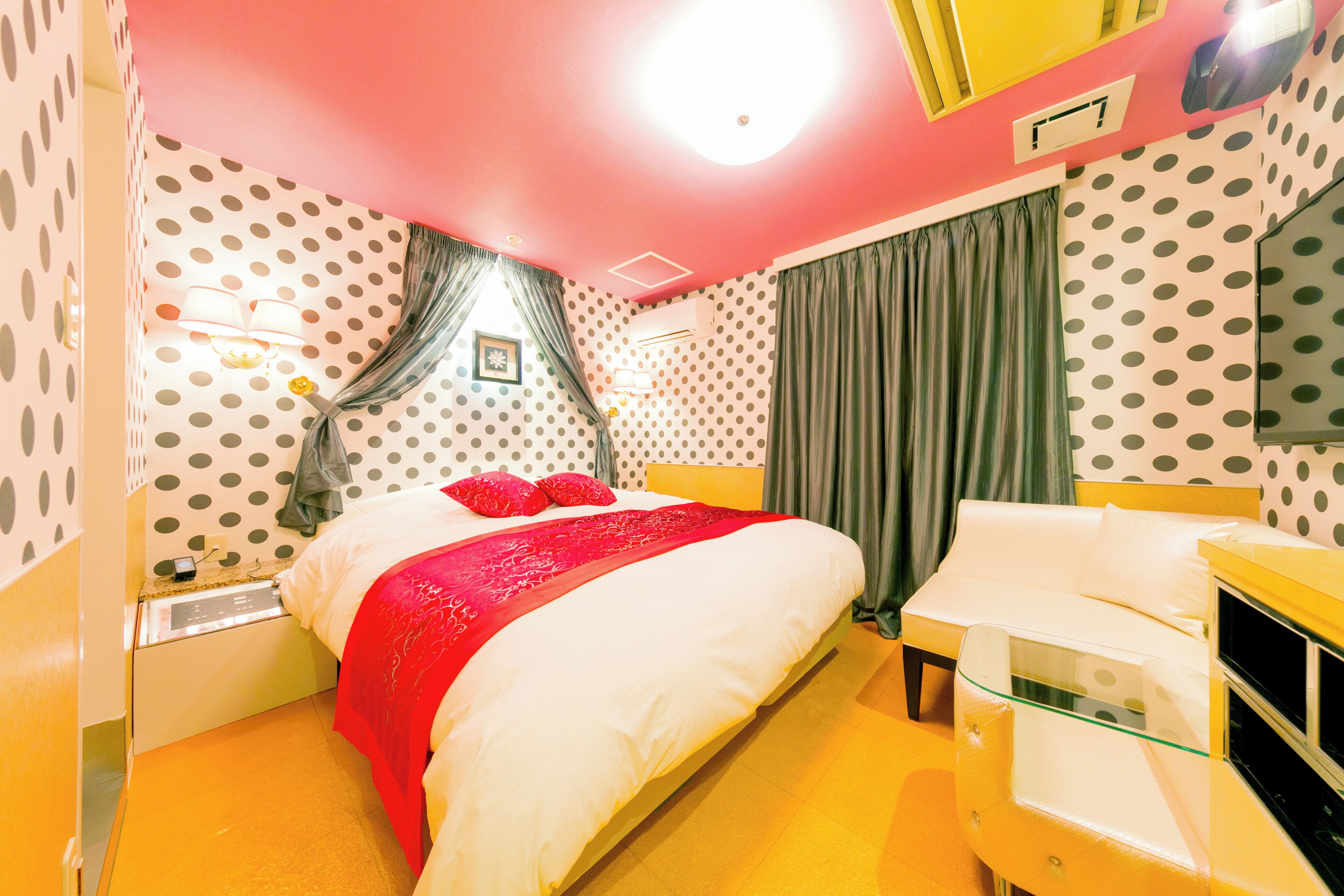 A room with a bed, a bedside table, a lamp, and a TV.