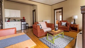 A compact living space with a kitchenette, a sofa set, a dining table, and a ceiling fan. - Peabody 3 Adorable Apartment (Memphis)