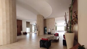 Eine großzügige Lobby mit gewölbter Decke, einer Rezeption und mehreren Sitzbereichen.