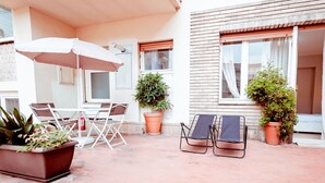 An outdoor patio with a table and chairs, a lounge chair, and potted plants. - Torino Centro, Repubblica Apartment (Torino)