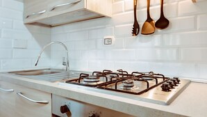 A modern kitchen with a gas stove, stainless steel sink, and wooden cabinets. - Torino Centro, Repubblica Apartment (Torino)