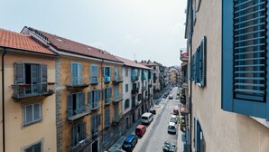 A narrow street lined with multi-story buildings, featuring balconies and a variety of architectural styles.