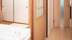 A traditional Japanese-style room with sliding doors, a tatami mat floor, and a bed with white bedding. - HANASTAY YANAGI (Osaka)