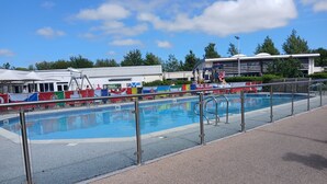 A swimming pool with a metal safety railing, surrounded by a paved walkway. - 3-Bed Caravan - Haven Lakeland Leisure Park (Grange-over-Sands)