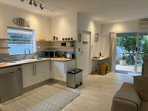 Enjoy a kitchen with a large window offering a view of the outdoors, appliances, and a convenient sink with a faucet.