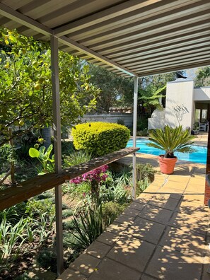 Relax by the serene pool surrounded by lush greenery and a modern design.