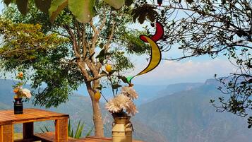 Una mesa de picnic de madera con un jarrón de flores y una decoración de globo aerostático.