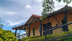 A building with a sloped roof, stone foundation, and a staircase leading to a porch. - Cabañas Cañón del Chicamocha (Aratoca)