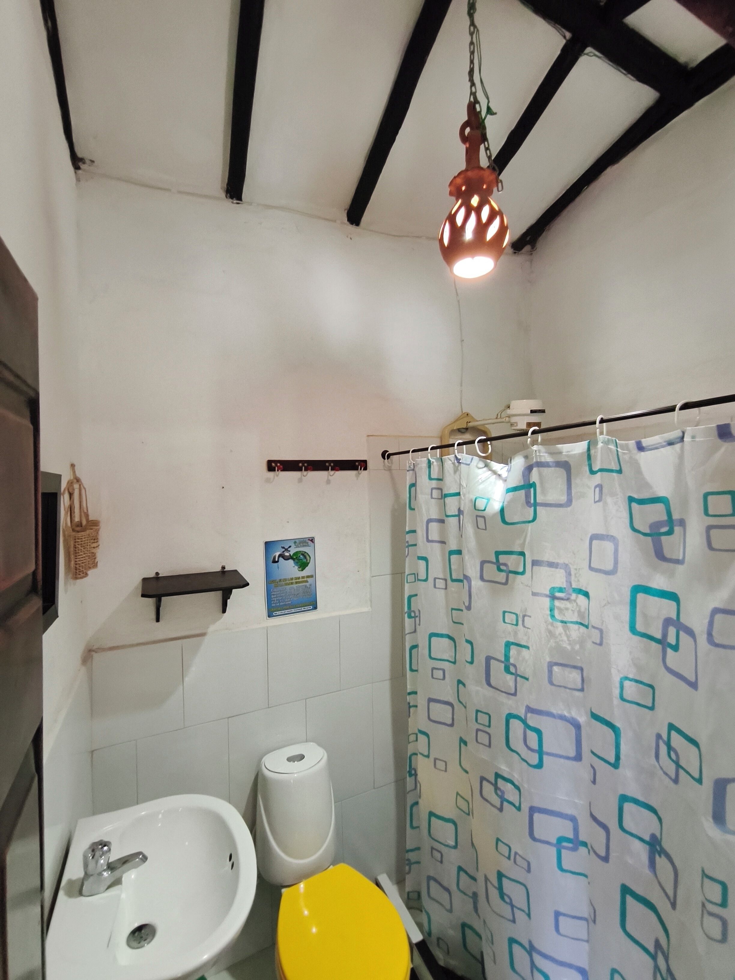 A bathroom with a sink, toilet, and shower curtain.