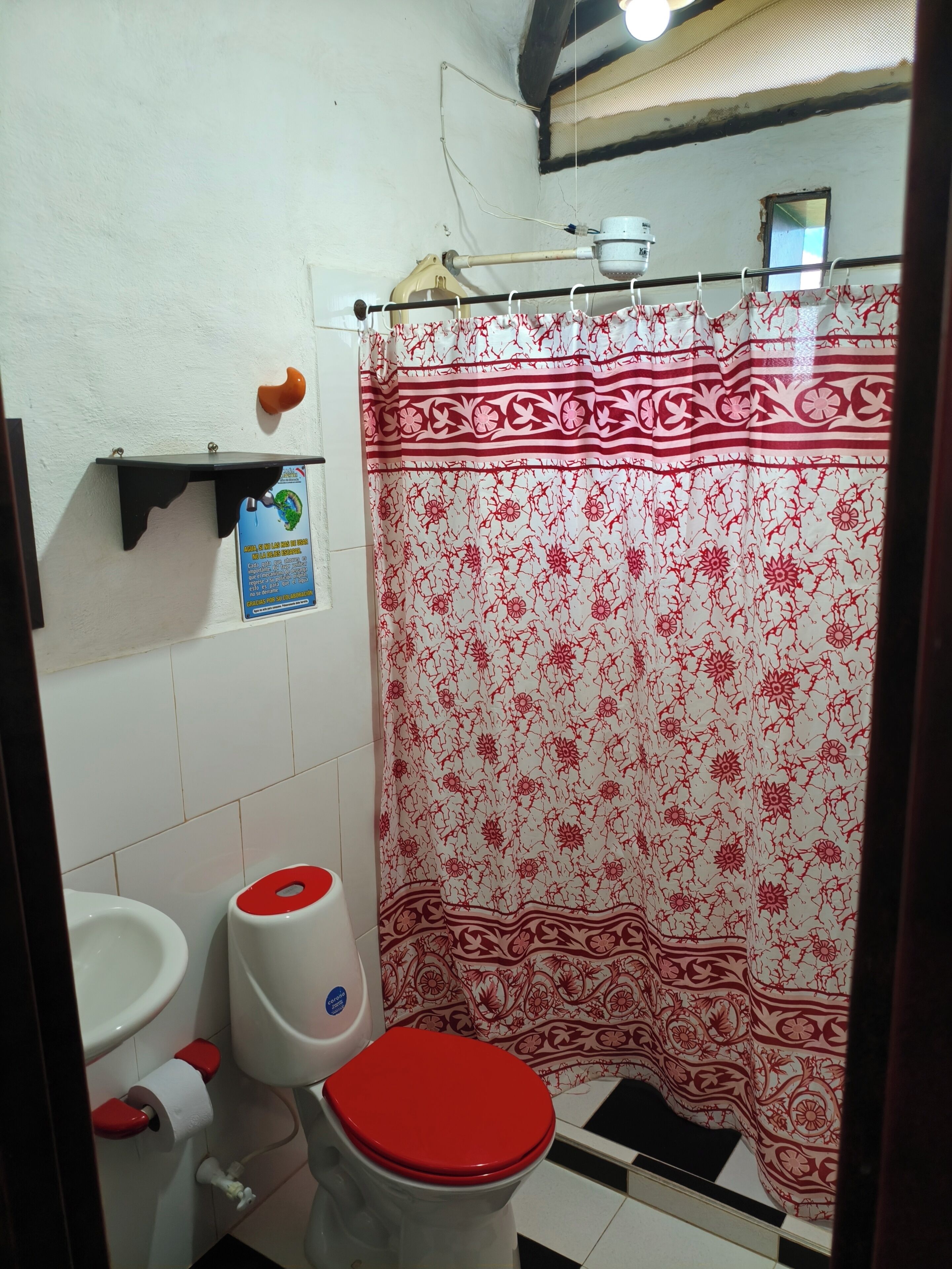 A bathroom with a toilet, sink, and shower curtain.
