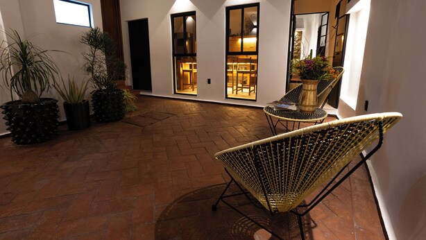 A spacious patio with a brick floor, wicker chairs, and potted plants. - Casa Sofi Oaxaca (Oaxaca)