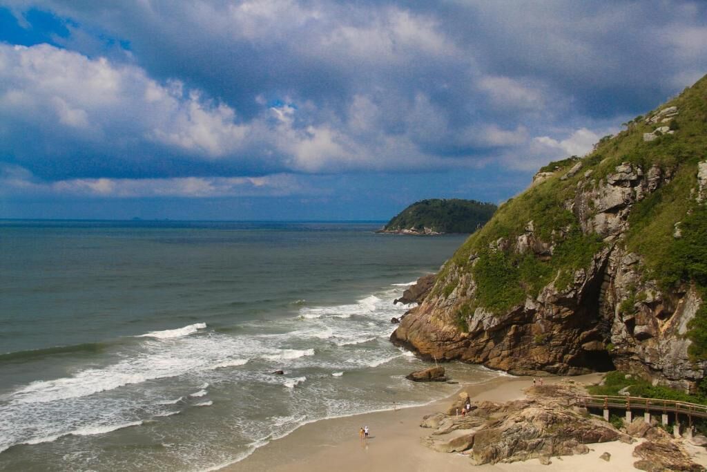 Una playa costera con acantilados rocosos y una vista despejada del océano.