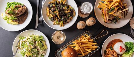 Variedad de platos que incluyen pasta, una hamburguesa y un plato de arroz y verduras.