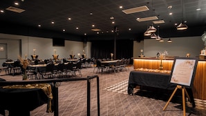 A banquet hall with multiple tables, chairs, and a reception area with a sign. - Unanderra Hotel  (Unanderra)