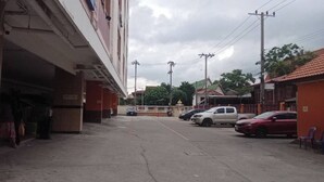 A street view with parked cars, buildings, and utility poles. - Buddy Mansion (Bangkok)