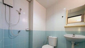A bathroom with a toilet, a sink, and a shower. - Buddy Mansion (Bangkok)