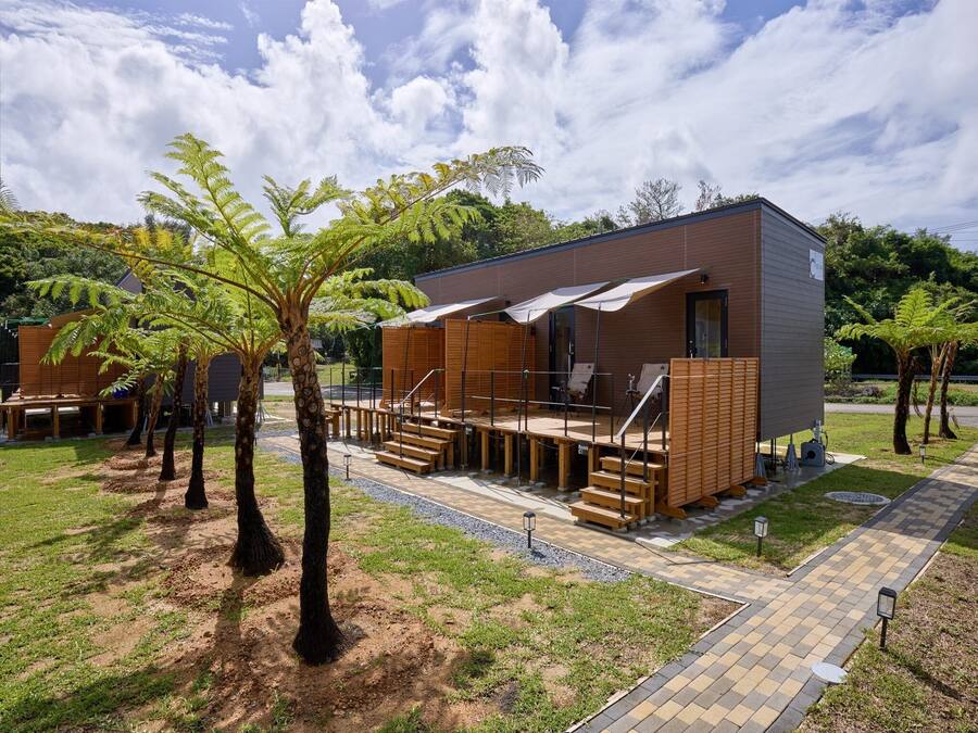 Un bâtiment moderne doté d’une terrasse, d’un espace salon extérieur et d’un sentier.