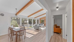 A spacious living area with a dining table, chairs, and a sofa.
