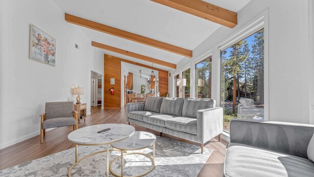 A modern living room with a grey sofa, a round coffee table, and a wooden ceiling.