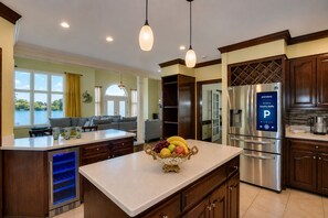 A kitchen with a central island, stainless steel appliances, and a view of a lake.