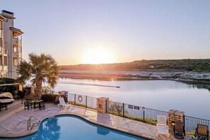 Una piscina con vista su un fiume e un tramonto.